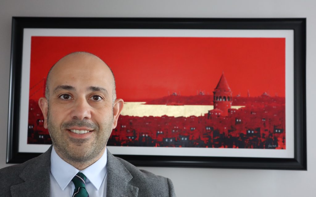 Avukat İltan Ekmekçioğlu kırmızı İstanbul fotoğrafının önünde yakın plan